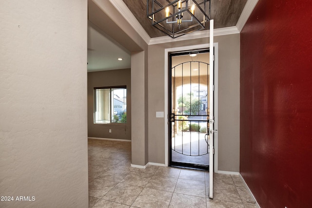 entrance foyer featuring crown molding, a chandelier, and light tile patterned floors