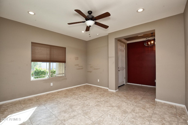 empty room with ceiling fan with notable chandelier