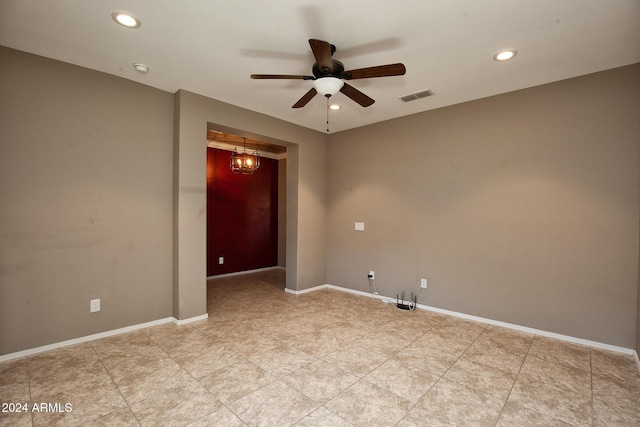 unfurnished room with ceiling fan with notable chandelier