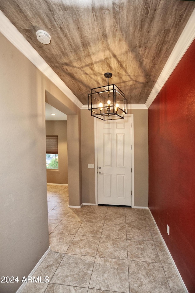 entrance foyer with crown molding, tile patterned flooring, and a notable chandelier