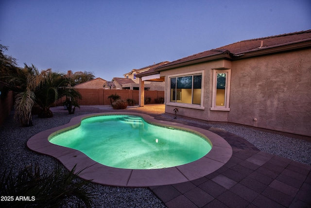 pool at dusk with a patio