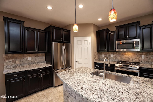 kitchen with pendant lighting, sink, tasteful backsplash, and stainless steel appliances