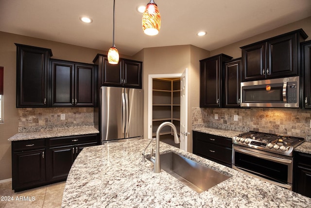 kitchen featuring appliances with stainless steel finishes, decorative light fixtures, sink, backsplash, and light tile patterned floors