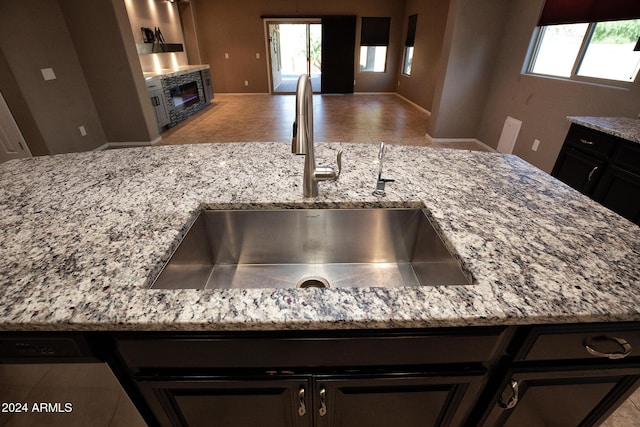 interior details featuring sink, light stone countertops, and dishwasher