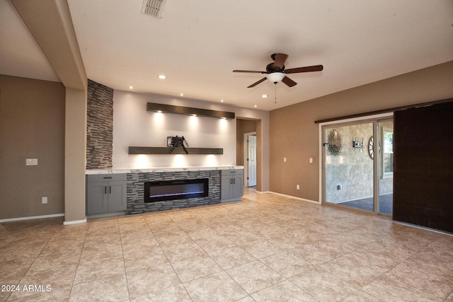 unfurnished living room with a fireplace and ceiling fan