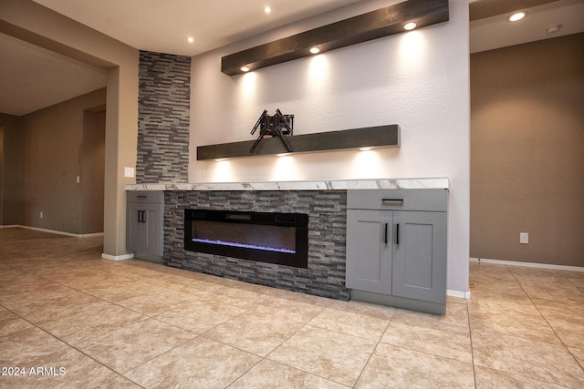 kitchen featuring gray cabinetry, light tile patterned floors, and a fireplace