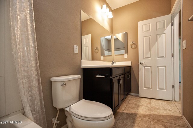 bathroom featuring a shower with shower curtain, vanity, toilet, and tile patterned flooring