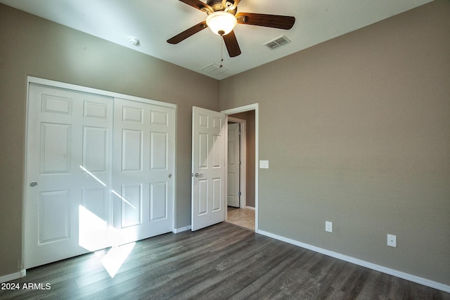 unfurnished bedroom featuring dark wood-type flooring, ceiling fan, and a closet