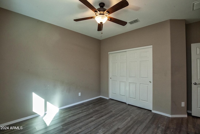 unfurnished bedroom with dark hardwood / wood-style flooring, a closet, and ceiling fan