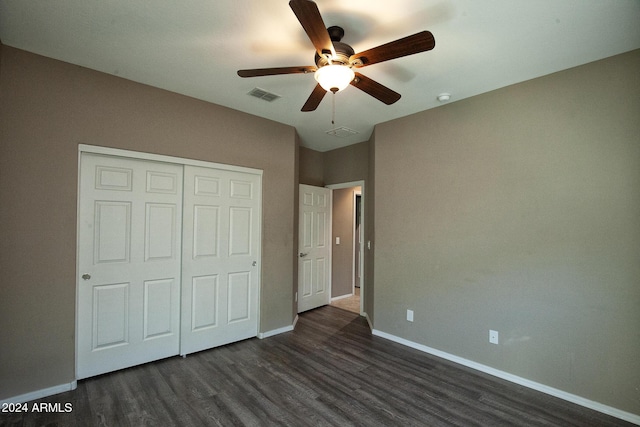 unfurnished bedroom with ceiling fan, dark hardwood / wood-style flooring, and a closet