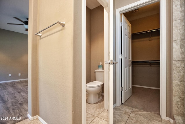 bathroom featuring ceiling fan, tile patterned floors, and toilet