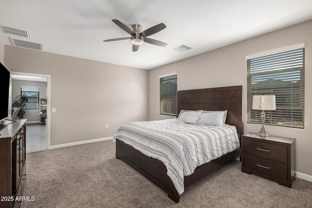 bedroom featuring baseboards, visible vents, a ceiling fan, and light colored carpet