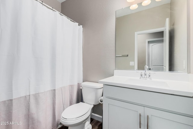 bathroom featuring toilet, curtained shower, and vanity