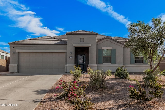 view of front of house with an attached garage, a tile roof, and stucco siding