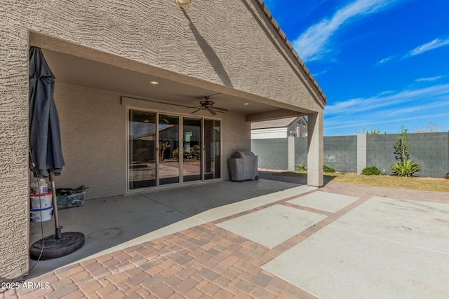 view of patio / terrace featuring area for grilling, fence, and a ceiling fan