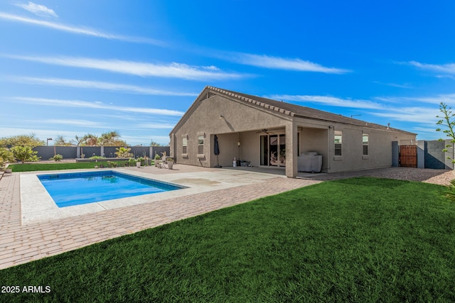 exterior space with a patio, stucco siding, a lawn, ceiling fan, and a fenced backyard