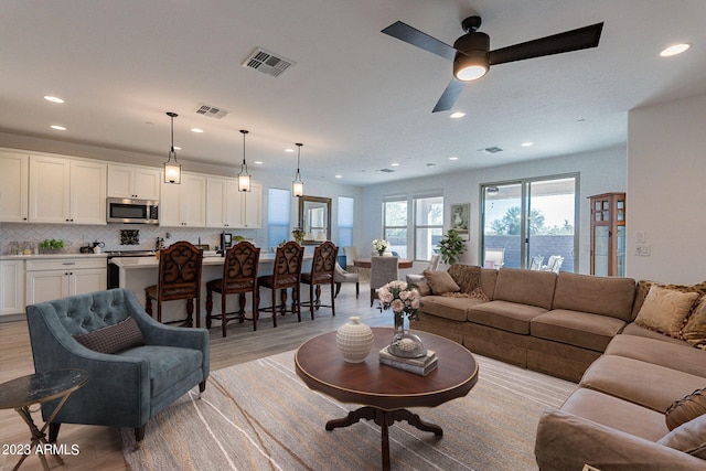 living room featuring ceiling fan and light hardwood / wood-style floors