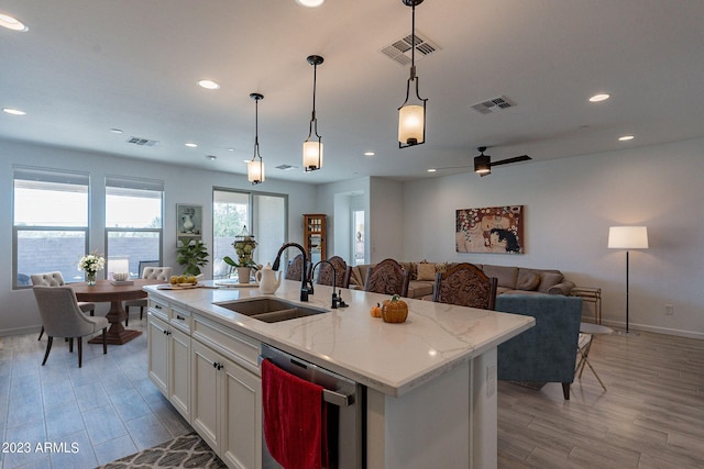 kitchen with white cabinets, visible vents, a sink, and dishwasher