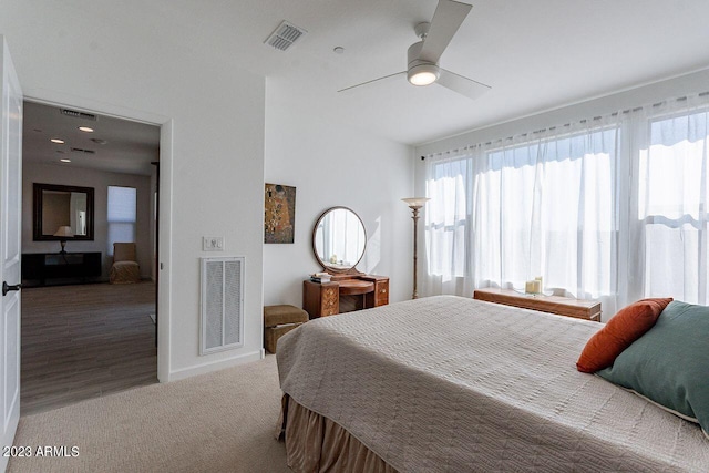 carpeted bedroom with baseboards, visible vents, and a ceiling fan