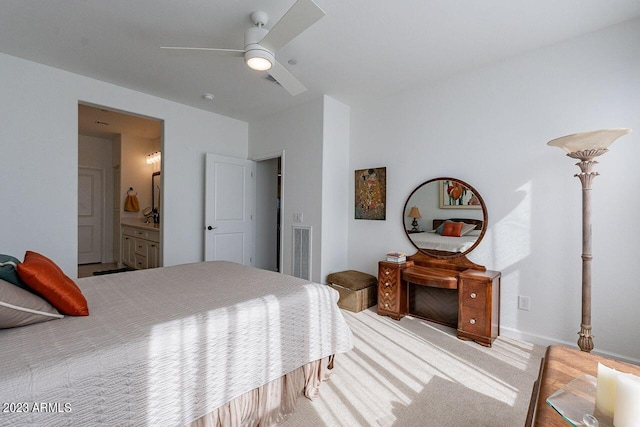 carpeted bedroom with visible vents, ceiling fan, and ensuite bathroom