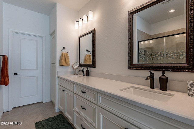 bathroom featuring tile patterned floors, a shower with shower door, and vanity