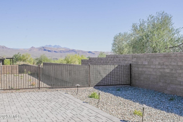 view of gate with fence and a mountain view