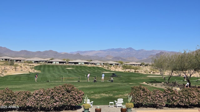 surrounding community with a mountain view and a lawn