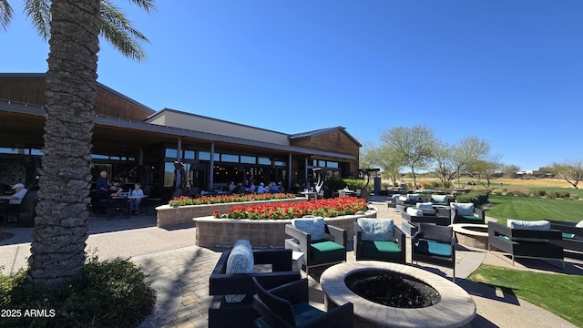 view of home's community with an outdoor living space with a fire pit and a patio