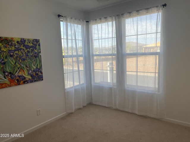 carpeted spare room with baseboards