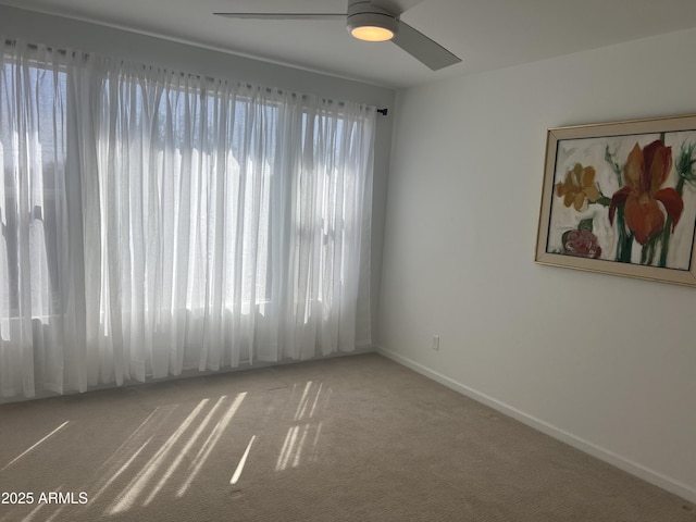 unfurnished room featuring ceiling fan, carpet flooring, and baseboards