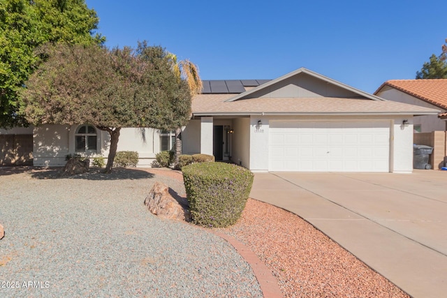 ranch-style home with a garage and solar panels