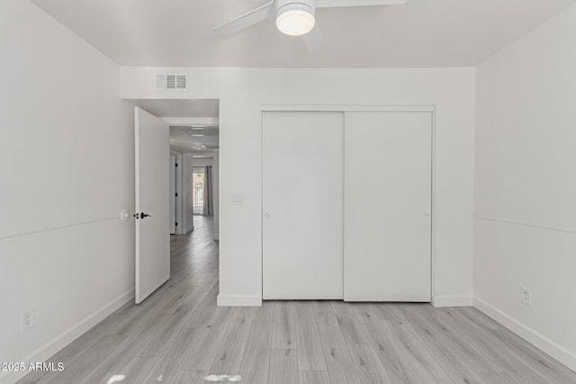 unfurnished bedroom with light hardwood / wood-style flooring, a closet, and ceiling fan