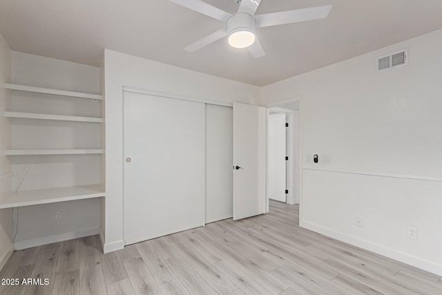 unfurnished bedroom featuring light hardwood / wood-style flooring, ceiling fan, and a closet