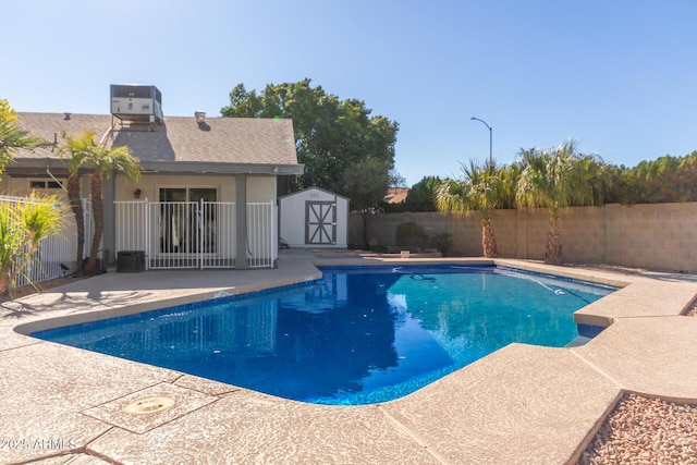 view of swimming pool featuring a patio, central AC, and a storage unit