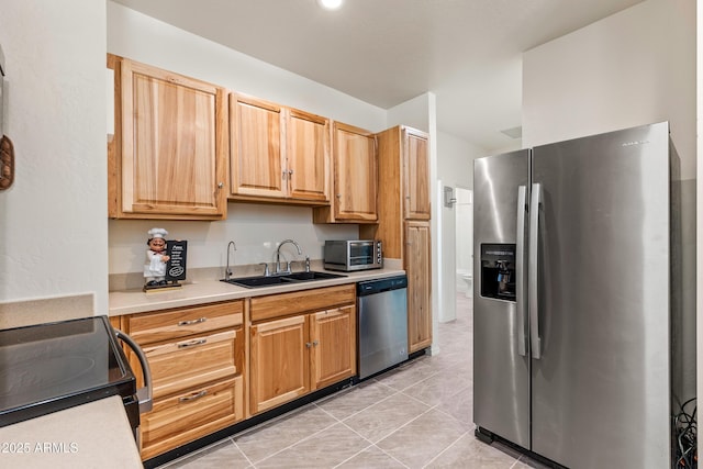 kitchen with a toaster, light tile patterned flooring, a sink, light countertops, and appliances with stainless steel finishes