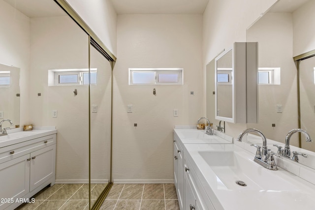 full bathroom featuring a sink, baseboards, and double vanity