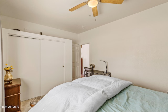 bedroom with a ceiling fan, a closet, and light carpet