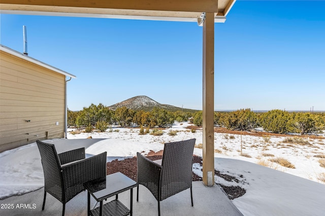 snow covered patio featuring a mountain view