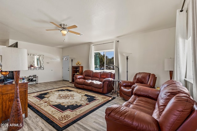 living room with a ceiling fan and wood finished floors