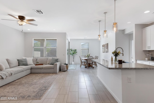 living area with plenty of natural light, visible vents, and recessed lighting