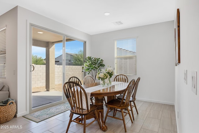 dining space with baseboards, visible vents, and a wealth of natural light