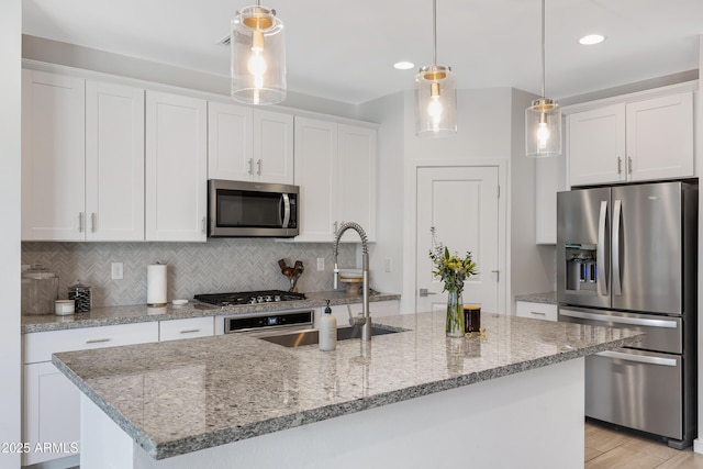 kitchen featuring appliances with stainless steel finishes, white cabinets, and backsplash