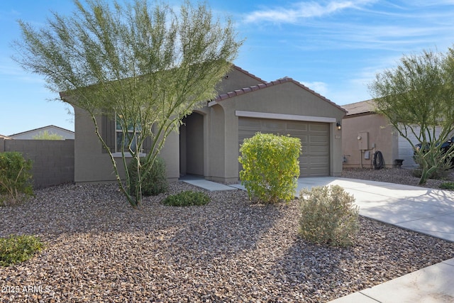 ranch-style home with an attached garage, fence, driveway, a tiled roof, and stucco siding