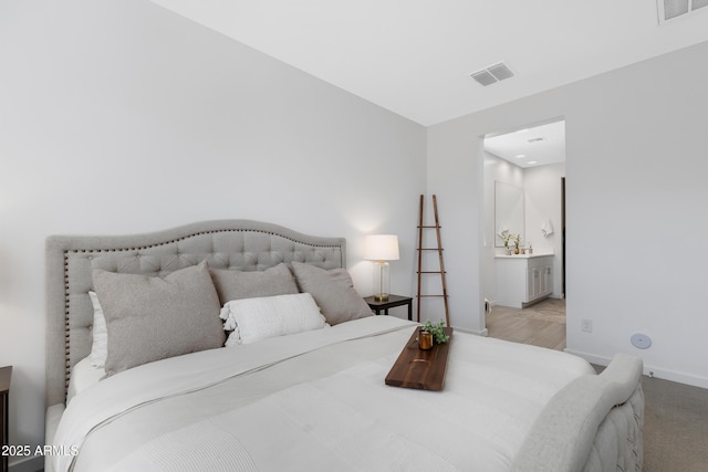 bedroom featuring visible vents, ensuite bath, and baseboards