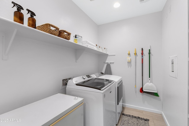 laundry room with laundry area, light wood-style flooring, baseboards, and washing machine and clothes dryer