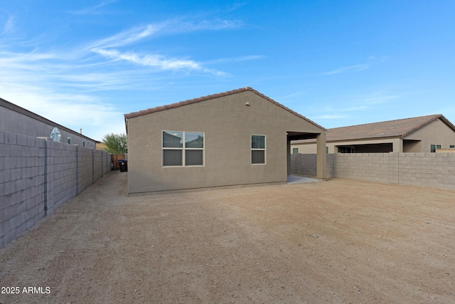 rear view of property with a fenced backyard and stucco siding