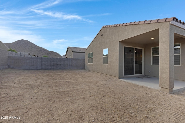 back of house featuring a patio, a fenced backyard, a mountain view, and stucco siding