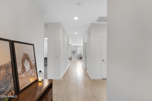 hallway with recessed lighting, visible vents, and baseboards