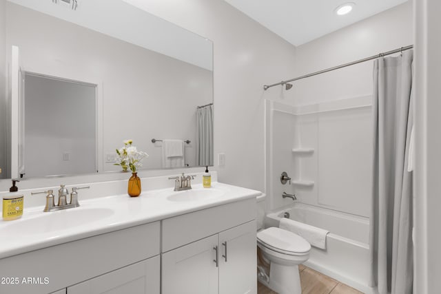 bathroom with double vanity, shower / bath combo, a sink, and toilet