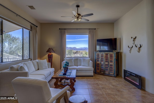 tiled living room featuring plenty of natural light and ceiling fan